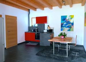 レンゲンフェルトにあるStudio Apartmentのキッチン(木製テーブル、赤いキャビネット付)