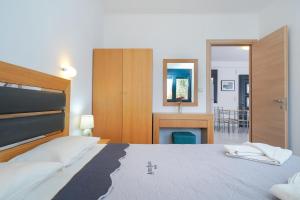 a bedroom with a bed and a desk and a mirror at Scandia Villas in Potos