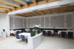 a dining room with white tables and chairs at Stadthotel GARNI Pinkafeld in Pinkafeld