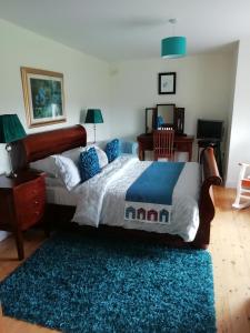 キルケニーにあるTig na Coille B&B Country Houseのベッドルーム1室(大型ベッド1台、青いラグ付)