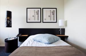 a bedroom with a bed and two pictures on the wall at Glostrup Park Hotel in Glostrup
