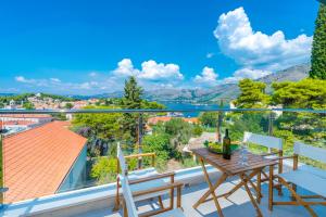 a balcony with a table and chairs and a view at Villa Nespola Penthouse in Cavtat