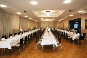 un gran salón de banquetes con mesas y sillas blancas en Stadthotel Pinkafeld, en Pinkafeld