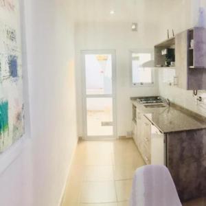 cocina blanca con encimera y puerta en C1 Suite, en Las Varillas 17 fotos más