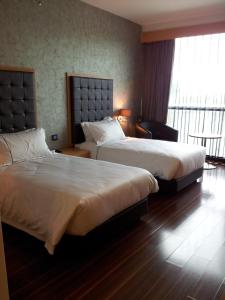 a hotel room with two beds and a window at Symphony Suites Hotel in Ipoh