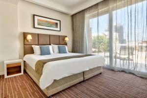 um quarto com uma cama grande e uma janela grande em The George, Urban Boutique Hotel em St Julian's