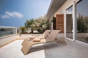 d'une terrasse avec 3 chaises sur un balcon. dans l'établissement The George, Urban Boutique Hotel, à San Ġiljan