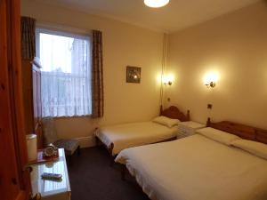 a hotel room with two beds and a window at Everley Guest House in Portsmouth