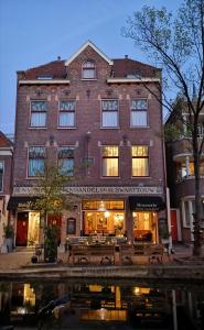 a large brick building in front of a building at Hotel Johannes Vermeer Delft in Delft