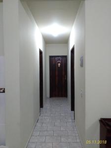 a hallway with a door and a tile floor at Apartamento itapoá 30 in Itapoa