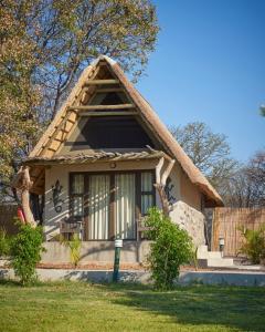 a small cottage with a thatched roof at Thamalakane River Lodge in Maun
