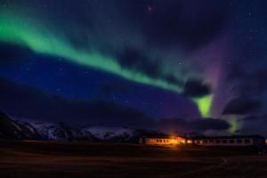 Eine Aurora am Himmel über einem Gebäude und einem Feld in der Unterkunft Hotel Langaholt in Langaholt