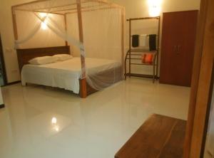 ein Schlafzimmer mit einem Himmelbett in der Unterkunft Lake Villa in Habaraduwa Central