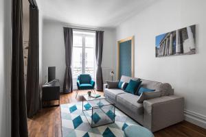 a living room with a couch and a table at Le Prestige by Cocoonr in Nantes