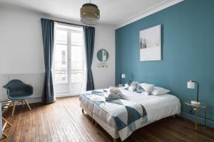 um quarto azul com uma cama e uma cadeira em Le Prestige by Cocoonr em Nantes