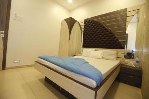 um quarto com uma cama grande e uma cabeceira em madeira em Hotel Al Moazin em Mumbai