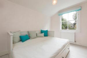 ロンドンにあるTranquil 2-bed flat, 20 mins from Hyde Parkの窓付きの客室の白いベッド1台