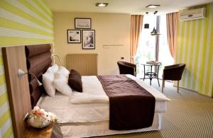 a hotel room with a bed and a table at Hotel Capitolina City Chic in Cluj-Napoca