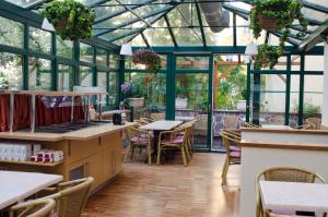 a restaurant with a conservatory with tables and chairs at Anna Hotel in Prague