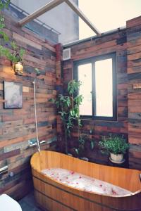 a bath tub in a room with wooden walls at The Gallery House in Hanoi