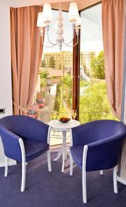 a dining room with a table and chairs and a window at Hotel Capitolina City Chic in Cluj-Napoca