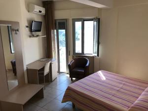 a bedroom with a bed and a desk and a chair at Hotel San Luca in Rossano