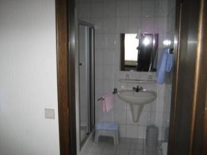 La salle de bains est pourvue d'un lavabo et d'un miroir. dans l'établissement Hotel Saint-Hubert, à Malmedy