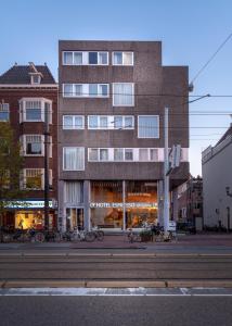 un edificio alto con bicicletas estacionadas frente a él en Hotel Espresso en Ámsterdam