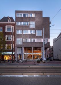 Un grand bâtiment avec des vélos garés devant lui dans l'établissement Hotel Espresso, à Amsterdam