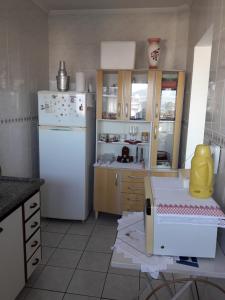 een keuken met een witte koelkast en houten kasten bij Apartamento inteiro in Praia Grande