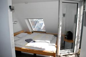 ケルンにあるHANSA PENTHOUSeの窓付きの小さな部屋のベッド1台分です。