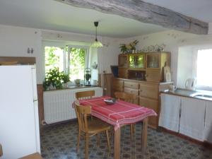 a kitchen with a table with a red table cloth on it at Au Jardin De Mon Père in Jalhay