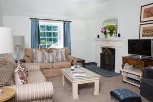 un soggiorno con divano e camino di The Old House, Llwyn Madoc a Llanwrtyd Wells