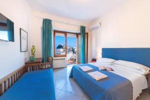 una camera con letto blu e balcone di Hotel Europa a Ischia