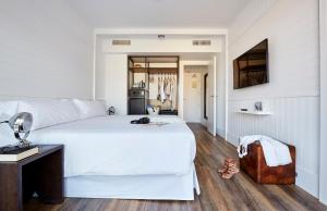 a bedroom with a large white bed and a desk at Delamar 4*Sup-Adults only (18+) in Lloret de Mar