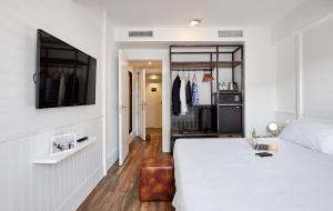 a bedroom with a bed and a tv on a wall at Delamar 4*Sup-Adults only (18+) in Lloret de Mar +37 photos