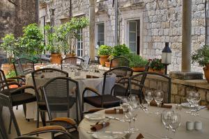 a restaurant with tables and chairs with wine glasses at The Pucic Palace in Dubrovnik