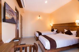 una camera d'albergo con due letti e una scrivania di Hotel Lake Shore a Pokhara