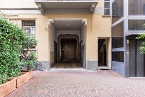 un corridoio vuoto di un edificio con porta in legno di SPAZIO M&M Via Augusto Anfossi 10 a Milano