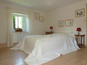 1 cama blanca en un dormitorio blanco con ventana en Au Jardin De Mon Père, en Jalhay