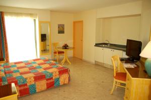 Schlafzimmer mit einem Bett, einem Schreibtisch und einem Tisch in der Unterkunft Hotel La Galleria in Le Lamentin