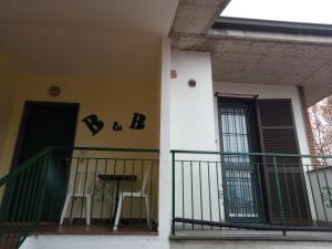 einen Balkon eines Hauses mit einem Tisch und einem Stuhl in der Unterkunft B&B MIke in Novi Ligure