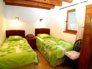 a bedroom with two beds and a chair and a window at La Roche Gite at Les Glycines Gites with Pool,Games Field in a peaceful,rural setting in Scillé