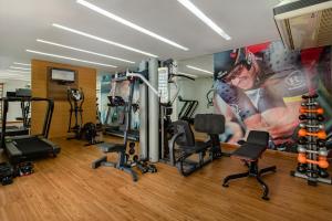 a gym with cardio equipment and a wall mural at Space Residence in Manaus
