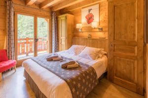 モルジヌにあるchalet le vanantの窓付きの部屋にベッド付きのベッドルーム1室があります。