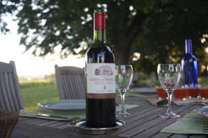 a bottle of wine sitting on a table with glasses at La chambre de la Tour in Lugon et l’Ile du Carney