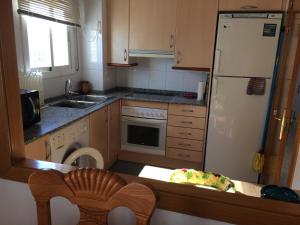 a kitchen with a white refrigerator and a table at Llastre in Hospitalet de l'Infant