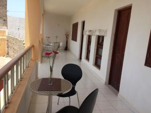 a balcony with a table with a vase of flowers on it at Vannilla Residencial in Mindelo