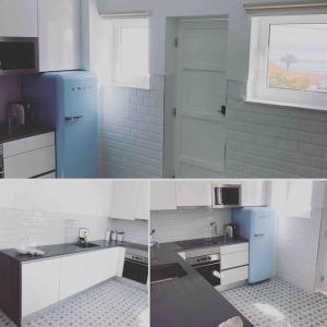 a kitchen with white cabinets and a blue refrigerator at SEA RIA - A casa dos Maria in Costa Nova