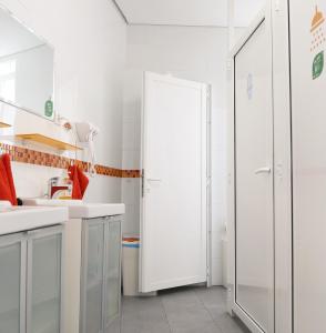 a bathroom with white cabinets and a glass door at Leon Hostel in León